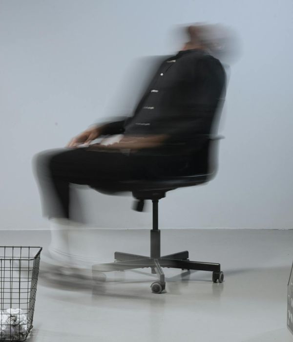 A person in dynamic motion in a minimalist studio.